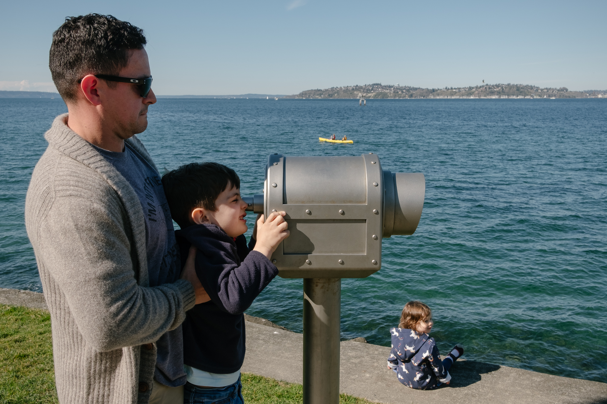 father holds son up to beach binoculars - documentary family photography