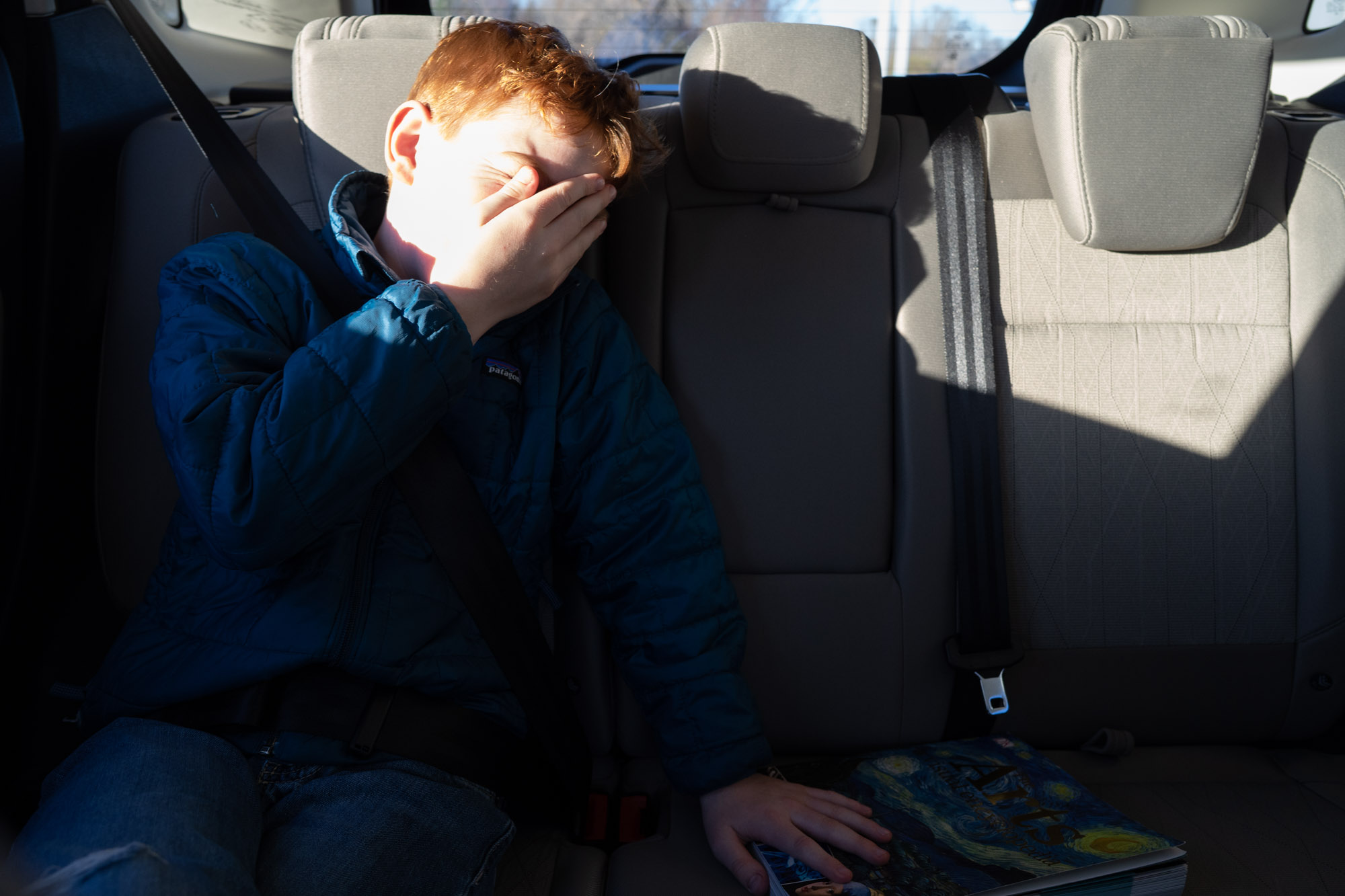 boy in sunlight in car -documentary family photography