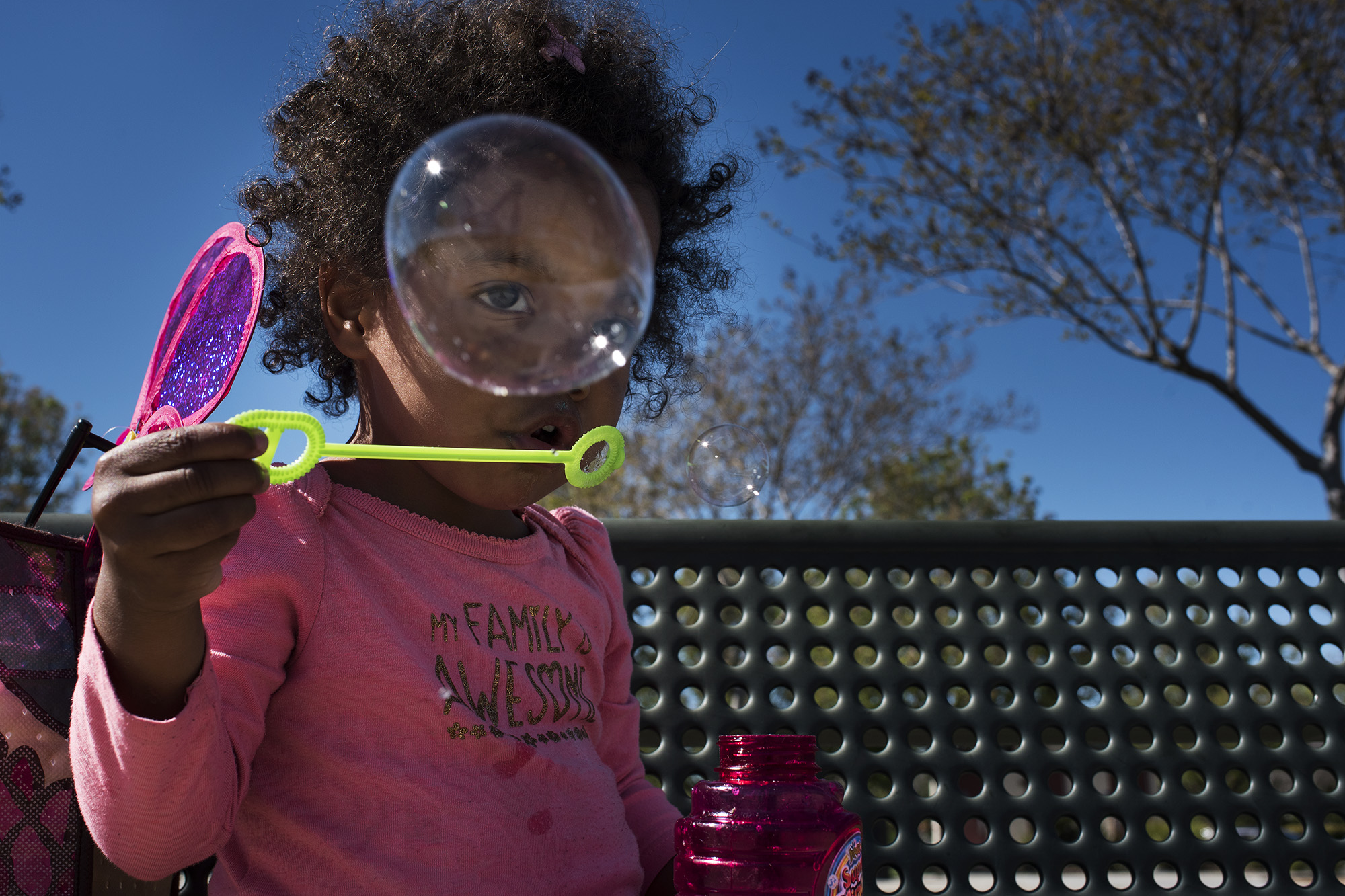 girl looking through bubble - documentary family photography