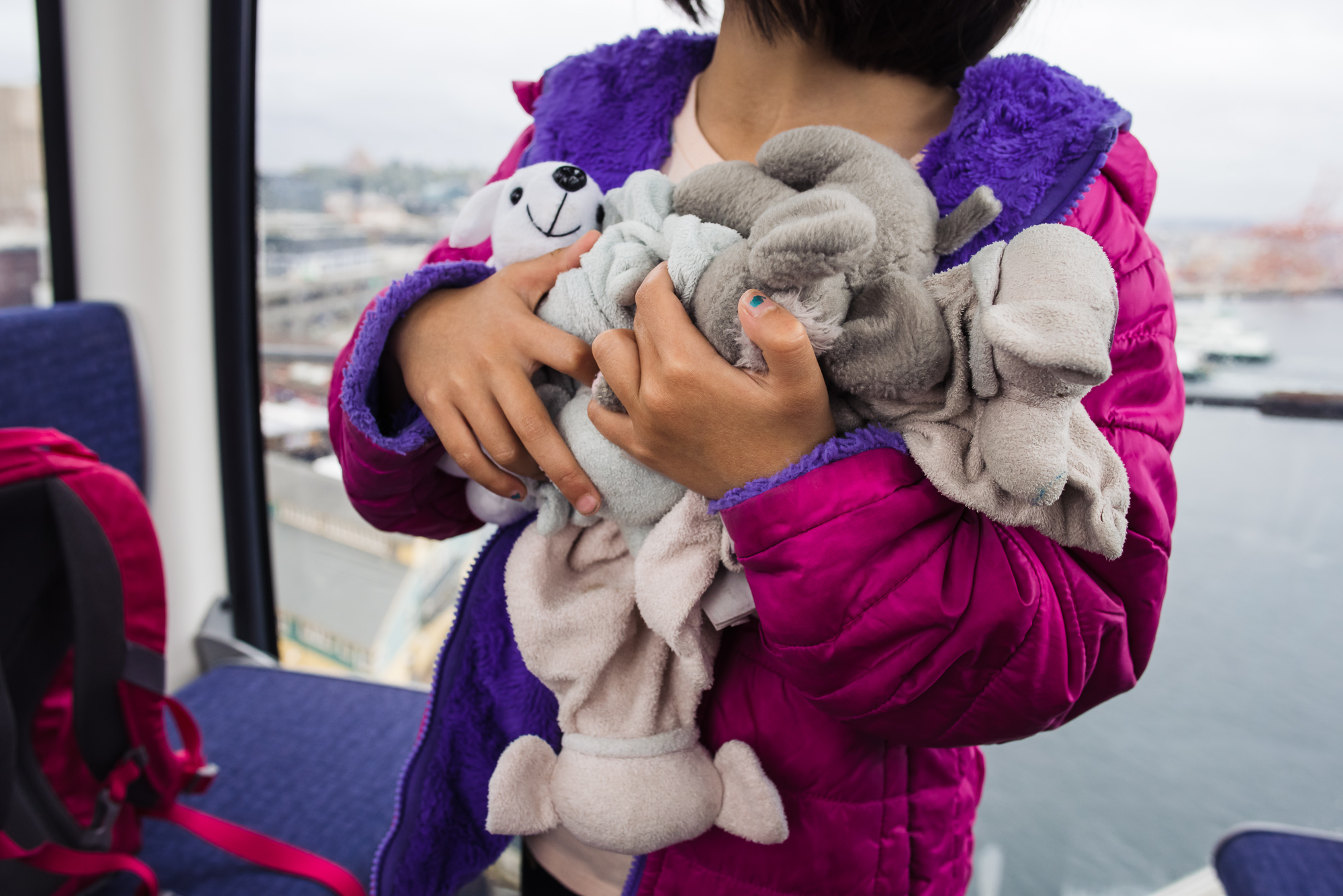 girl holding stuffed toys - documentary family photography