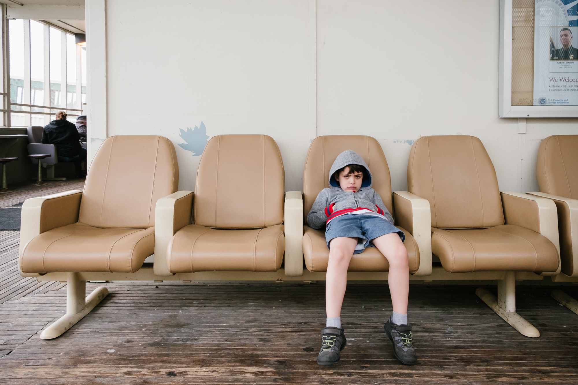 bored boy in ferry terminal - documentary family photography
