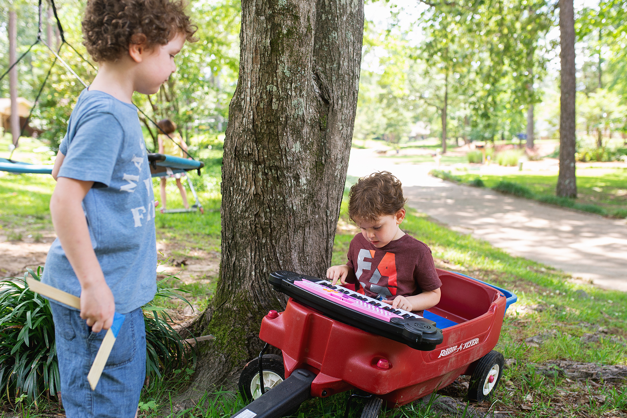 kid playing keyboard in wagon - documentary family photography