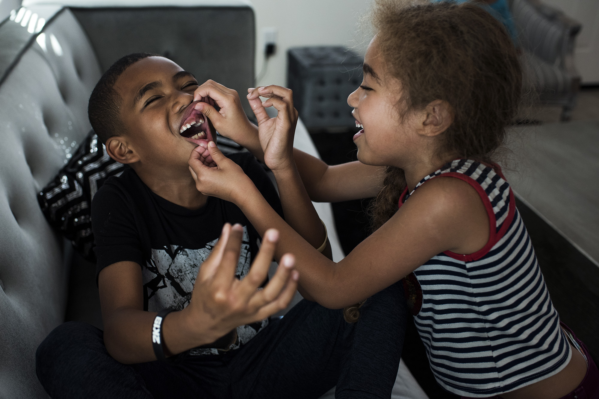 girl looking at brother's nose - documentary family photography