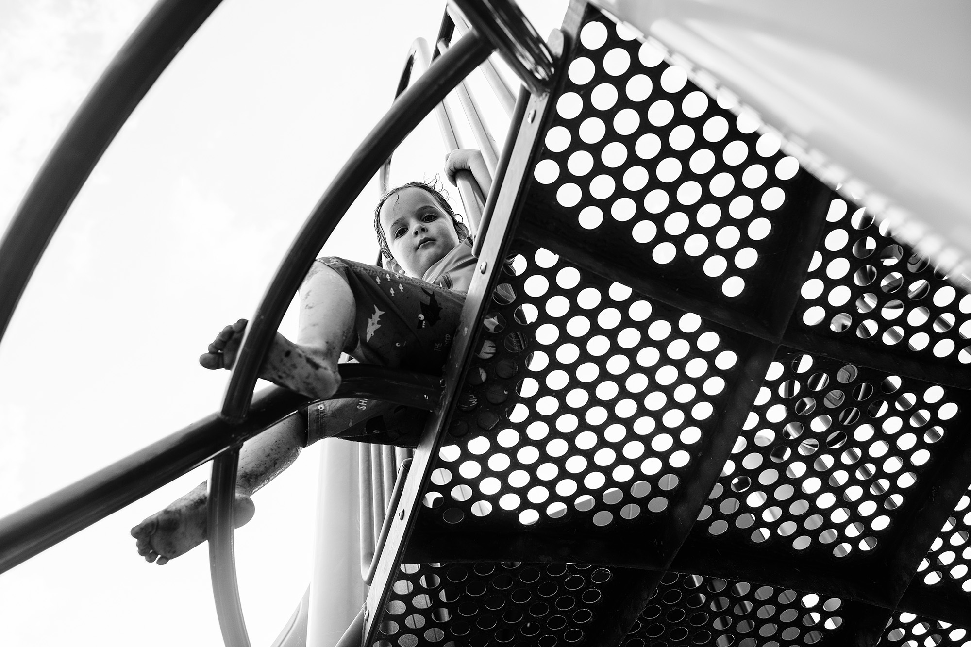 child on playground from below - documentary family photography