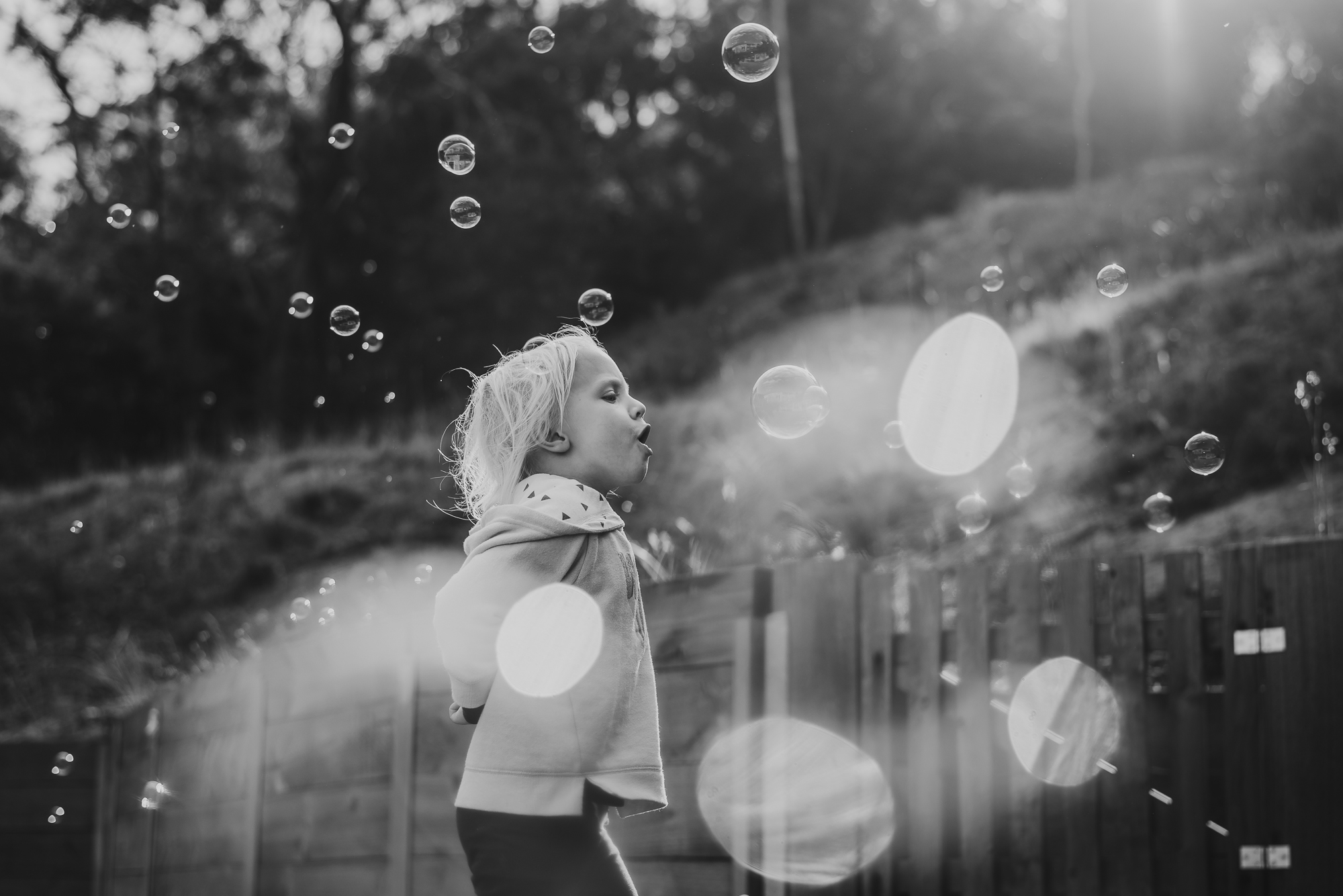 child playing in bubbles - documentary family photography