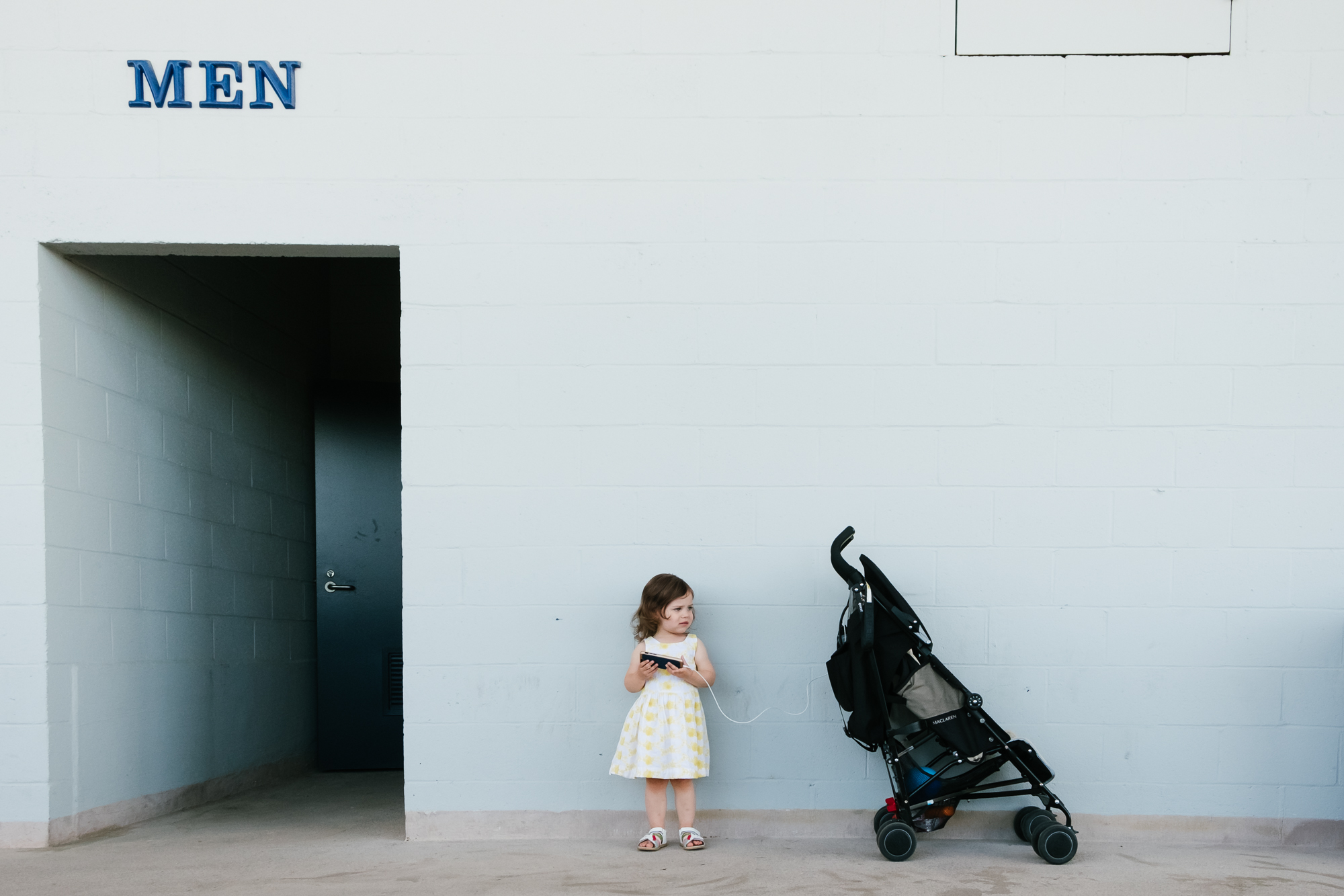 girl waiting outside restroom  - documentary family photography