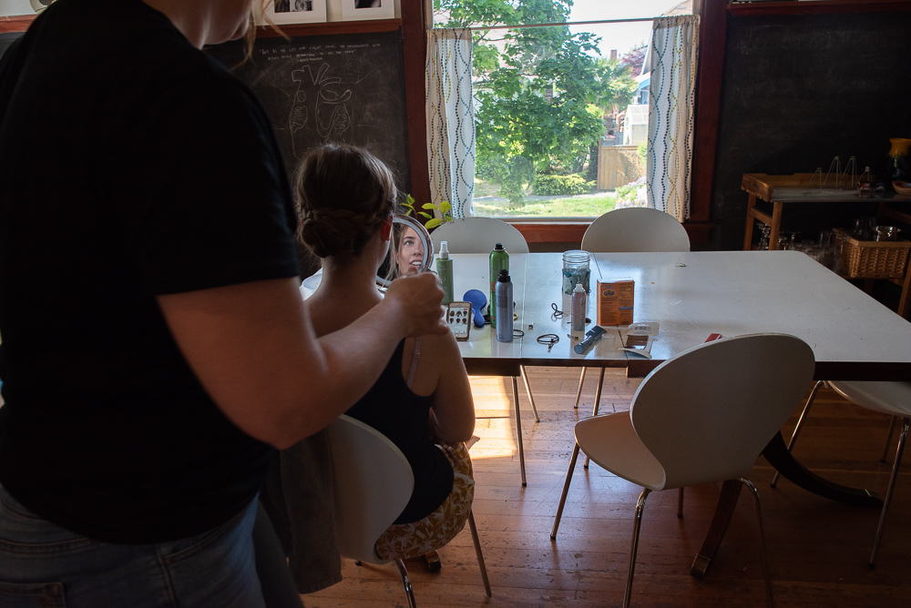 girl getting hair done at dining table - documentary family photography