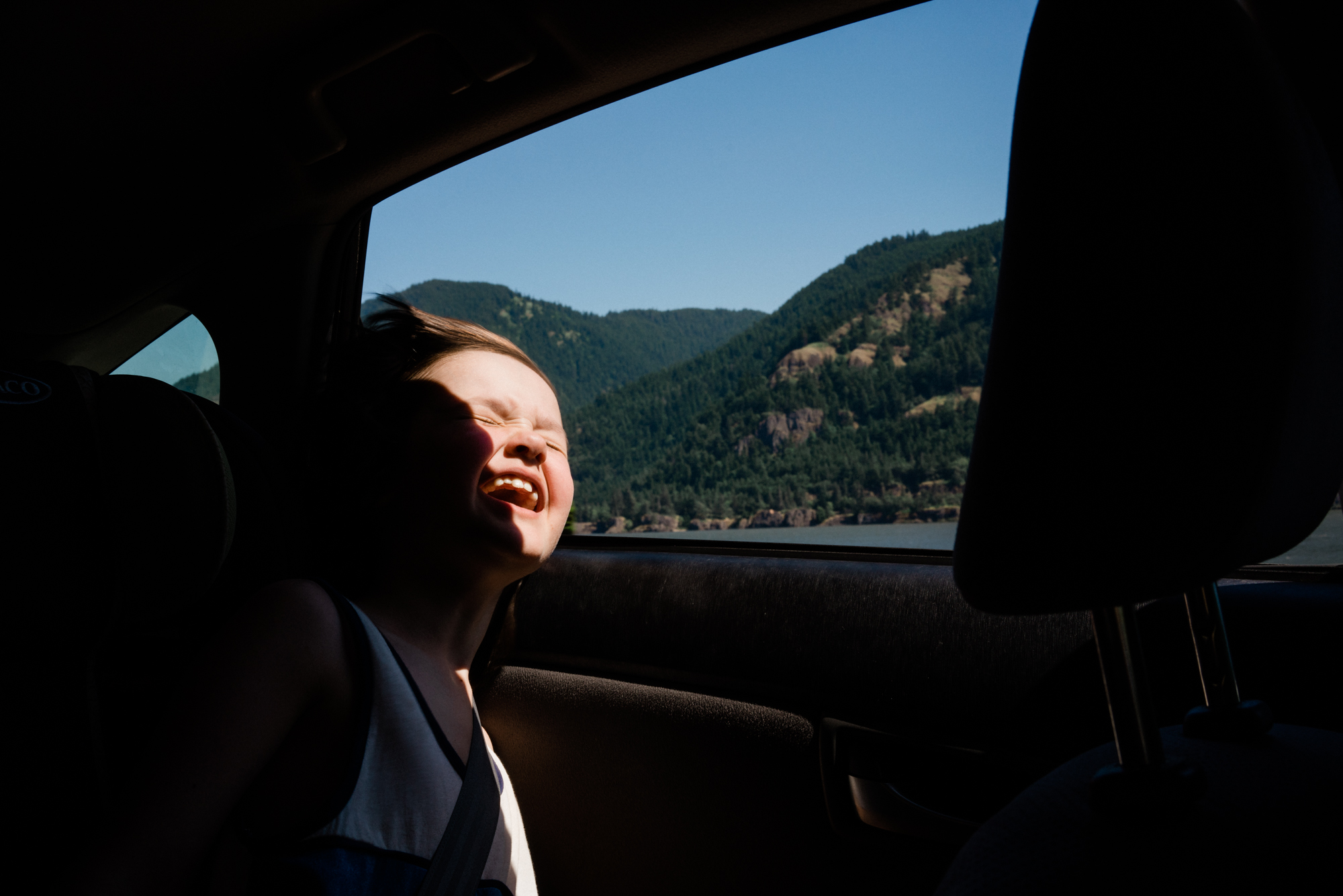 child leaning out window - documentary family photography