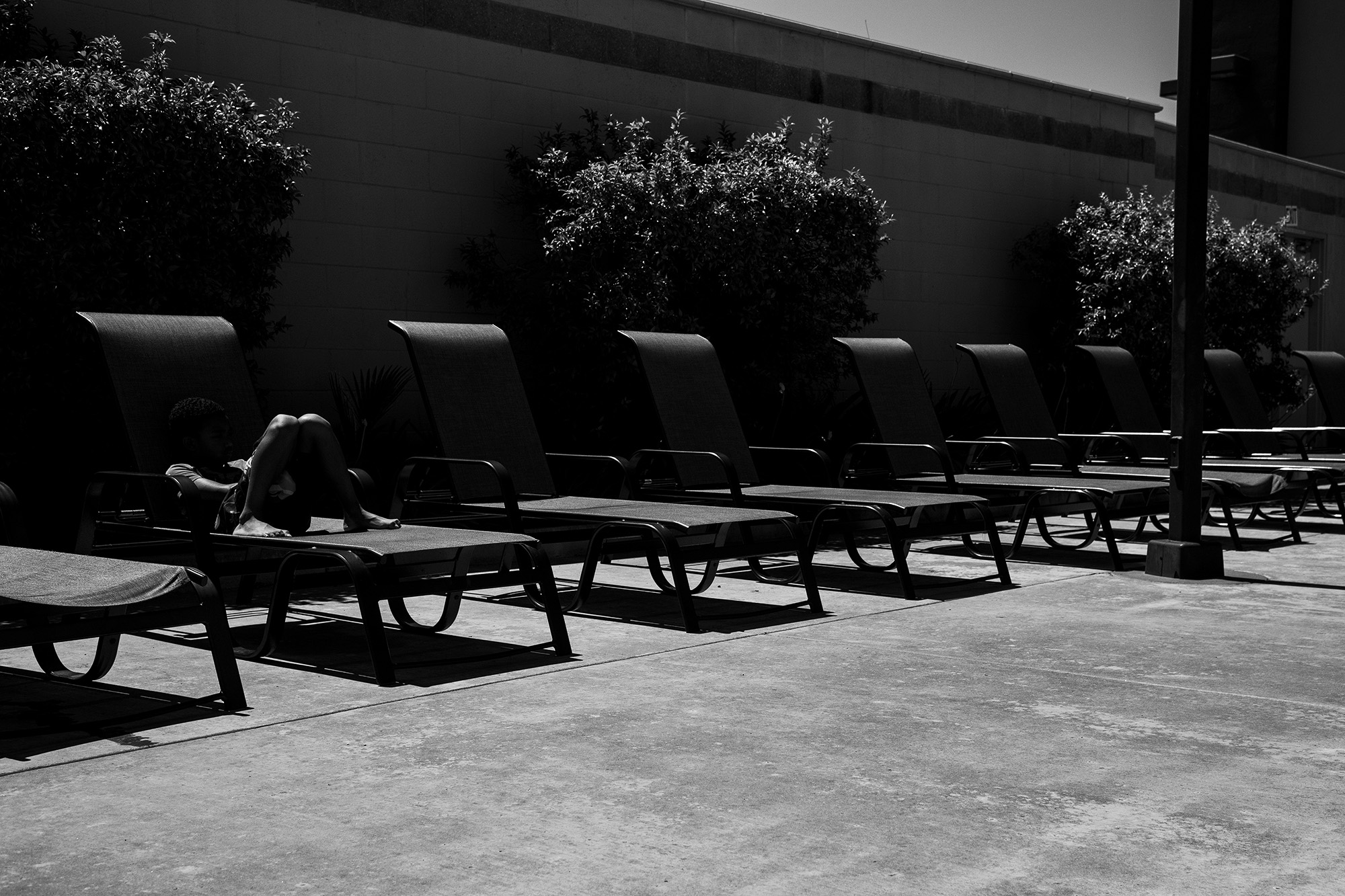 kid on pool chairs - documentary family photography