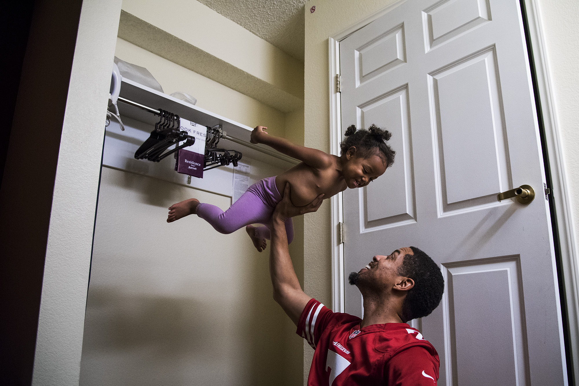 father lifting daughter - documentary family photography