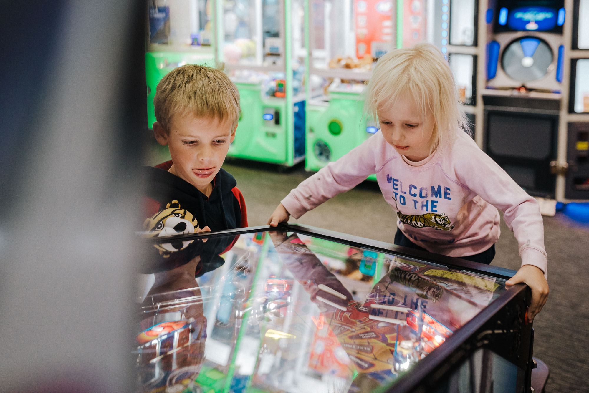 kids looking at arcade game - documentary family photography