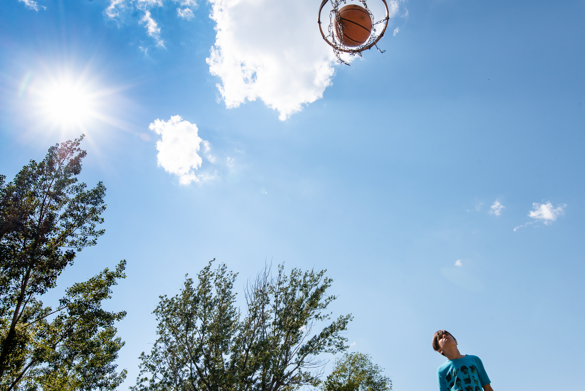 boy shoots basketball - documentary family photography