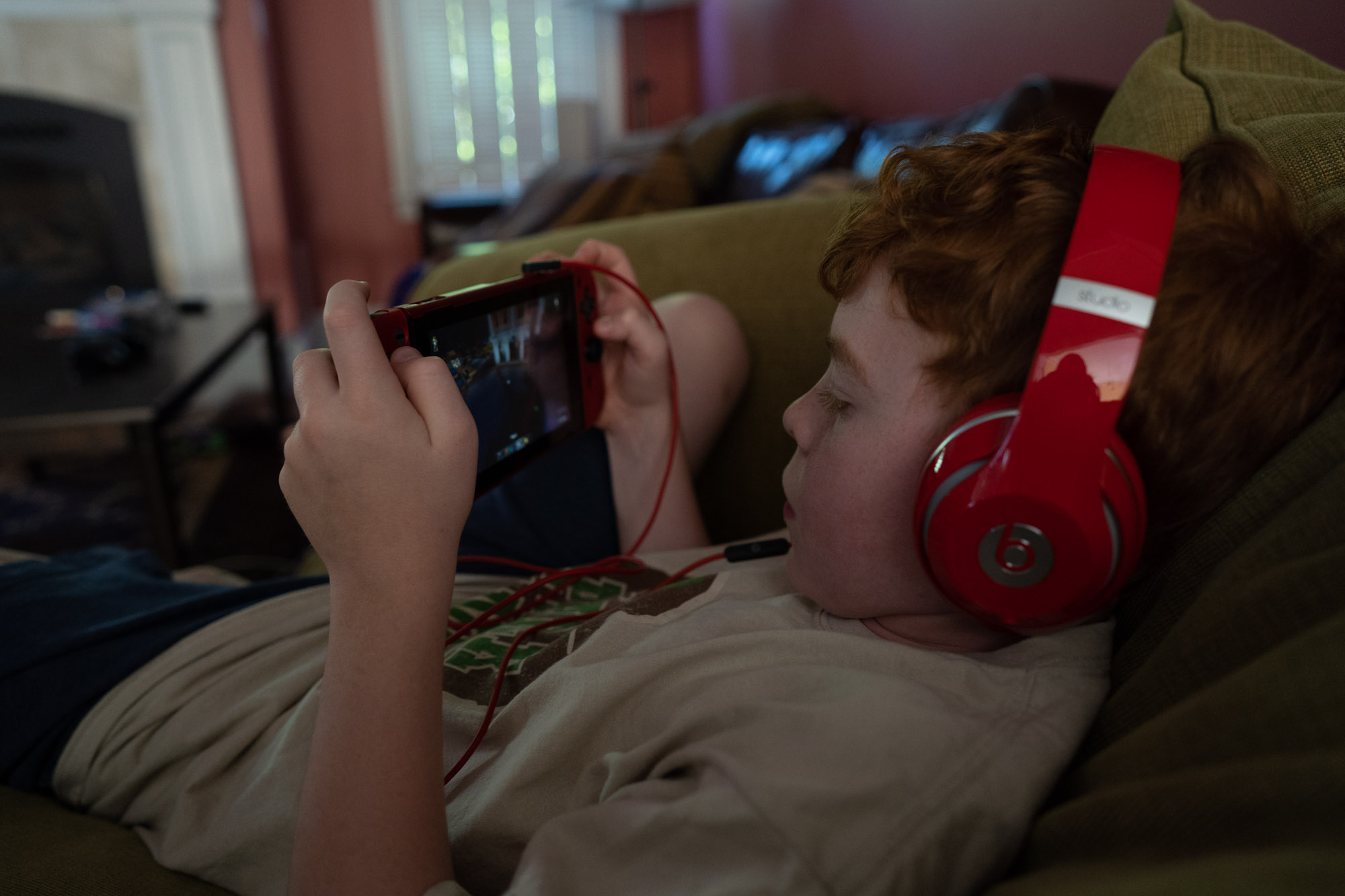 boy playing handheld game - documentary family photography