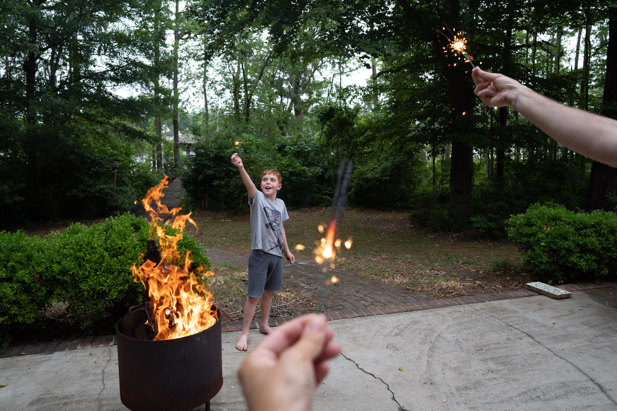 boy with sprinkler and BBQ pit - documentary family photography