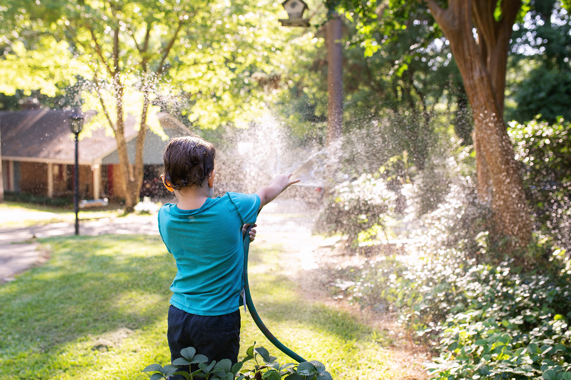 boy with hose - documentary family photography