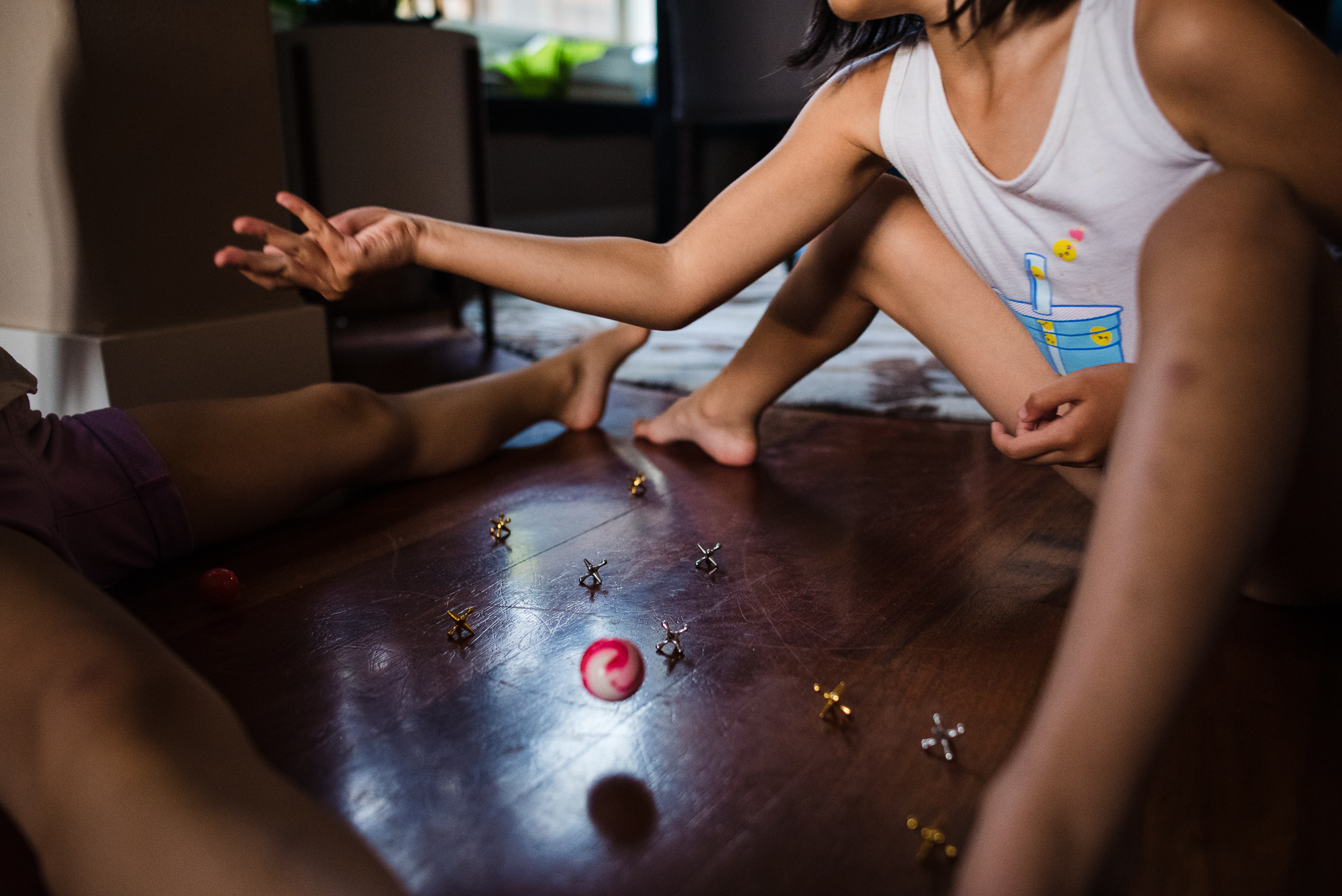 kid playing with jacks - documentary family photography