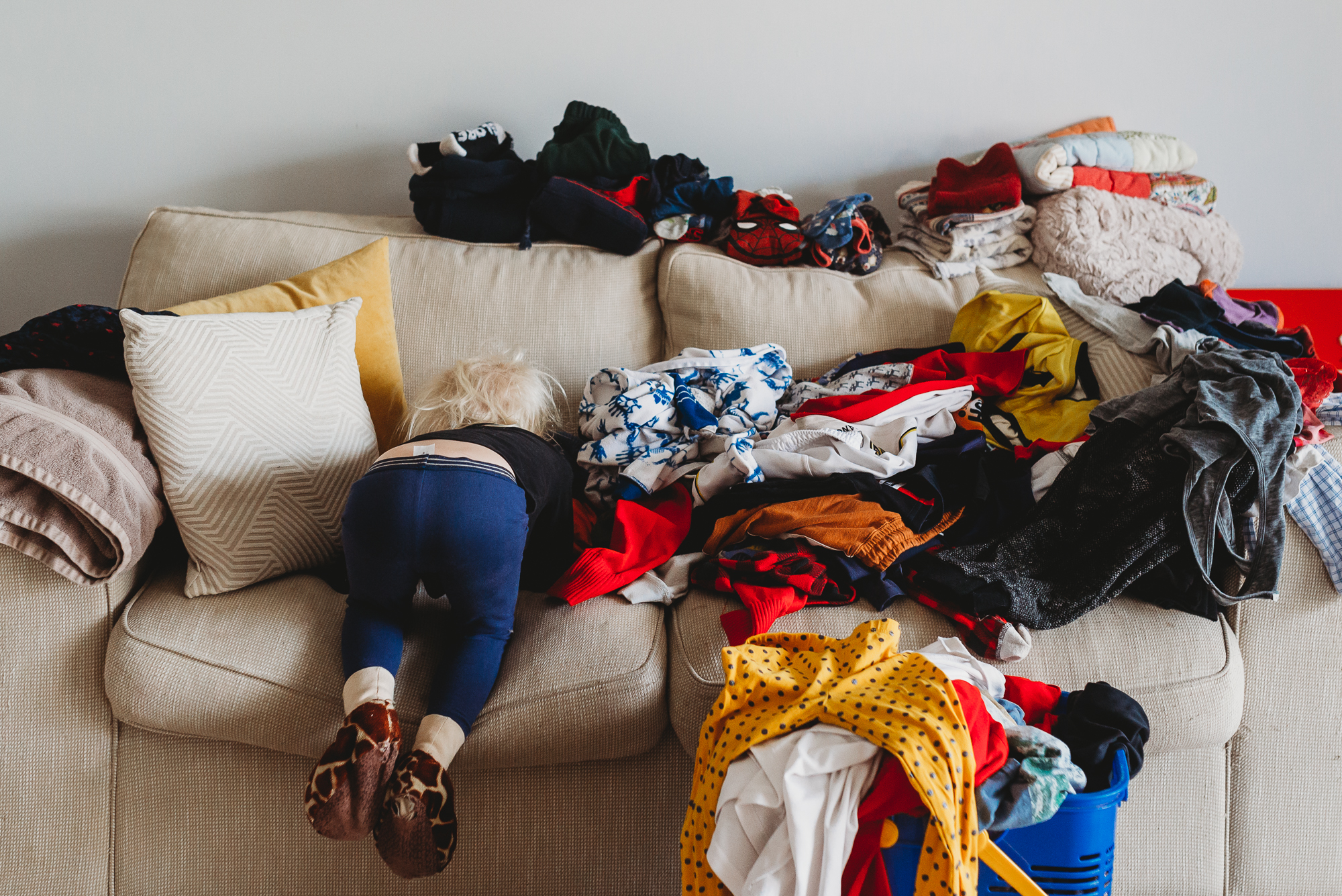 child on couch with laundry - documentary family photography