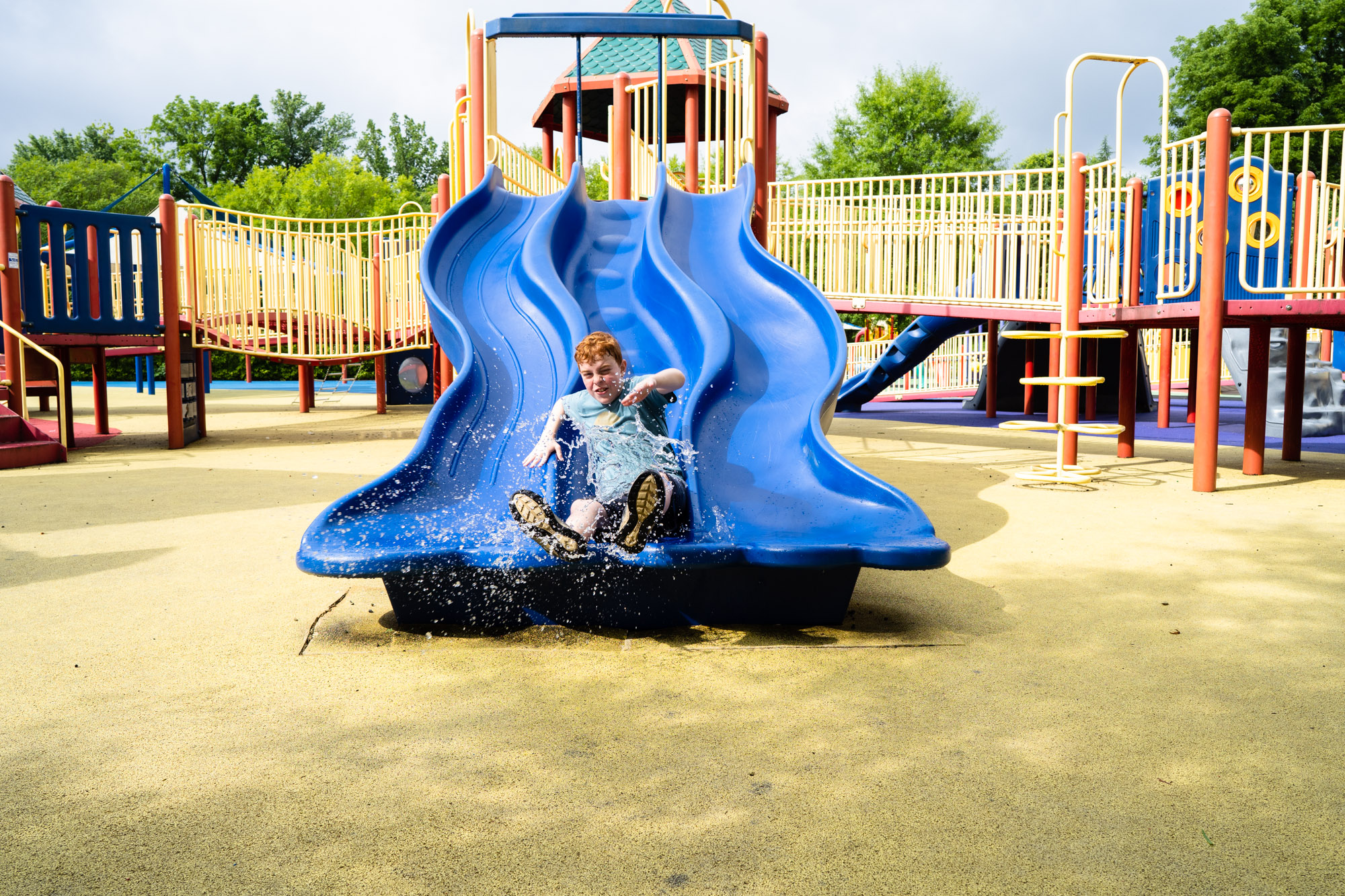 boy going down slide - documentary family photography